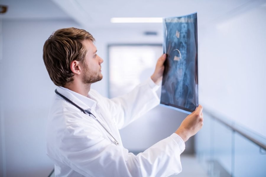 male-doctor-examining-x-ray-in-corridor-2023-11-27-05-07-50-utc.jpg